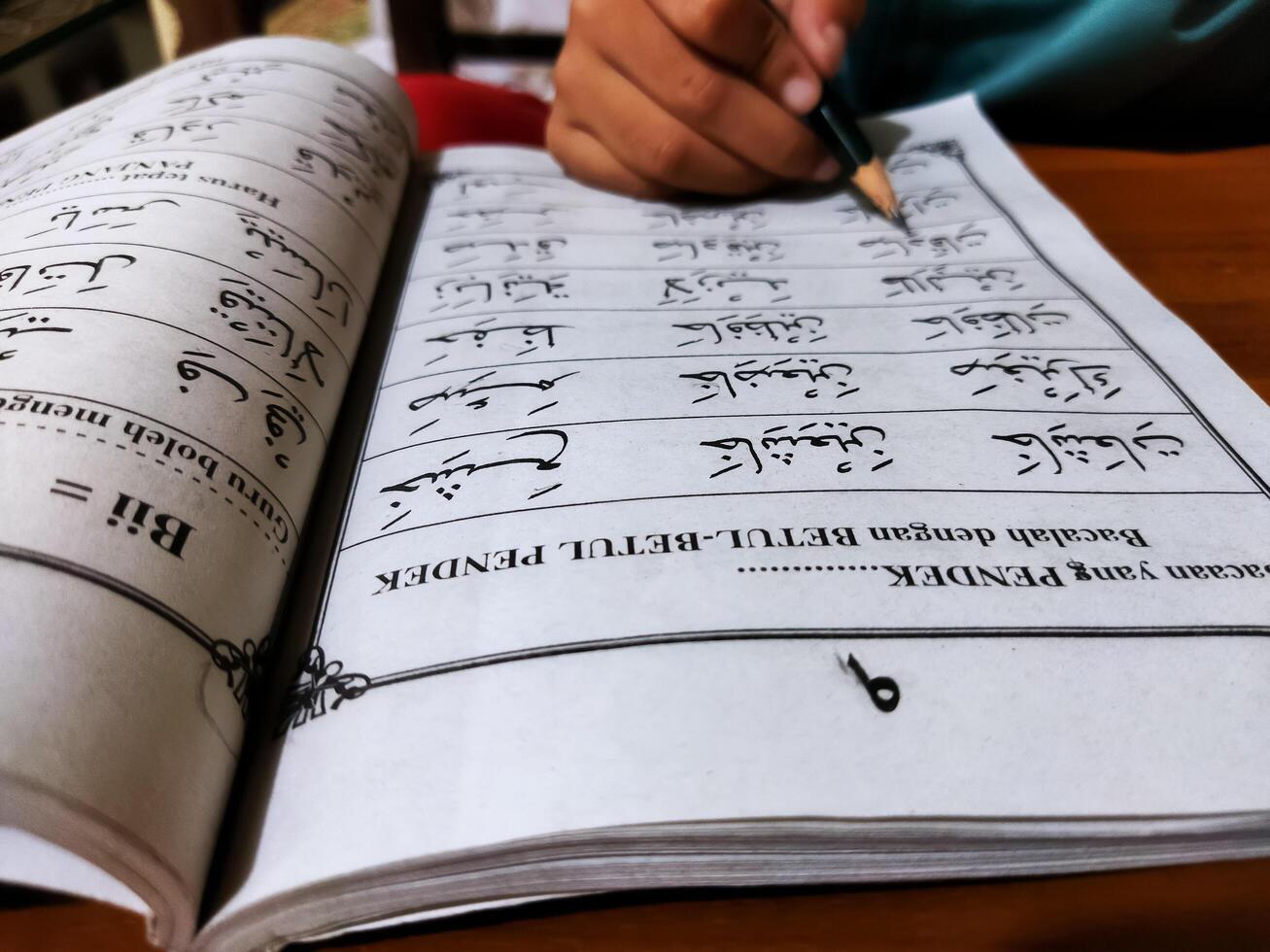 Bekonang, Sukoharjo, March 26, 2023. Islamic student is learning basic reading verses of the Quran by using the Iqra ', which is quick and clever methods at Islamic primary school. photo