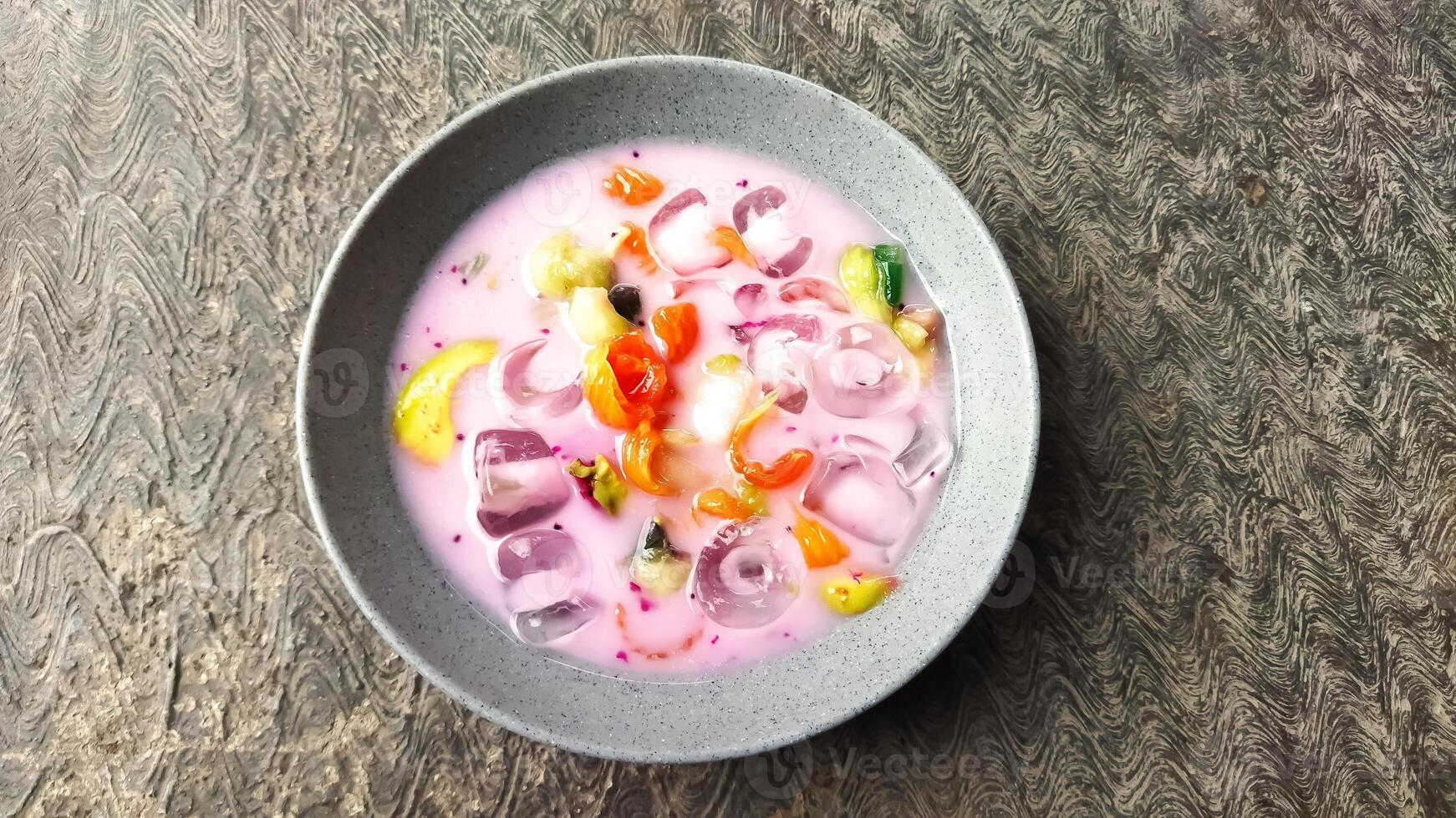 Es buah or sop buah-is an Indonesian iced fruit cocktail dessert. This cold and sweet beverage is made of diced fruits mixed with shaved ice or ice cubes, and sweetened with liquid sugar or syrup. photo