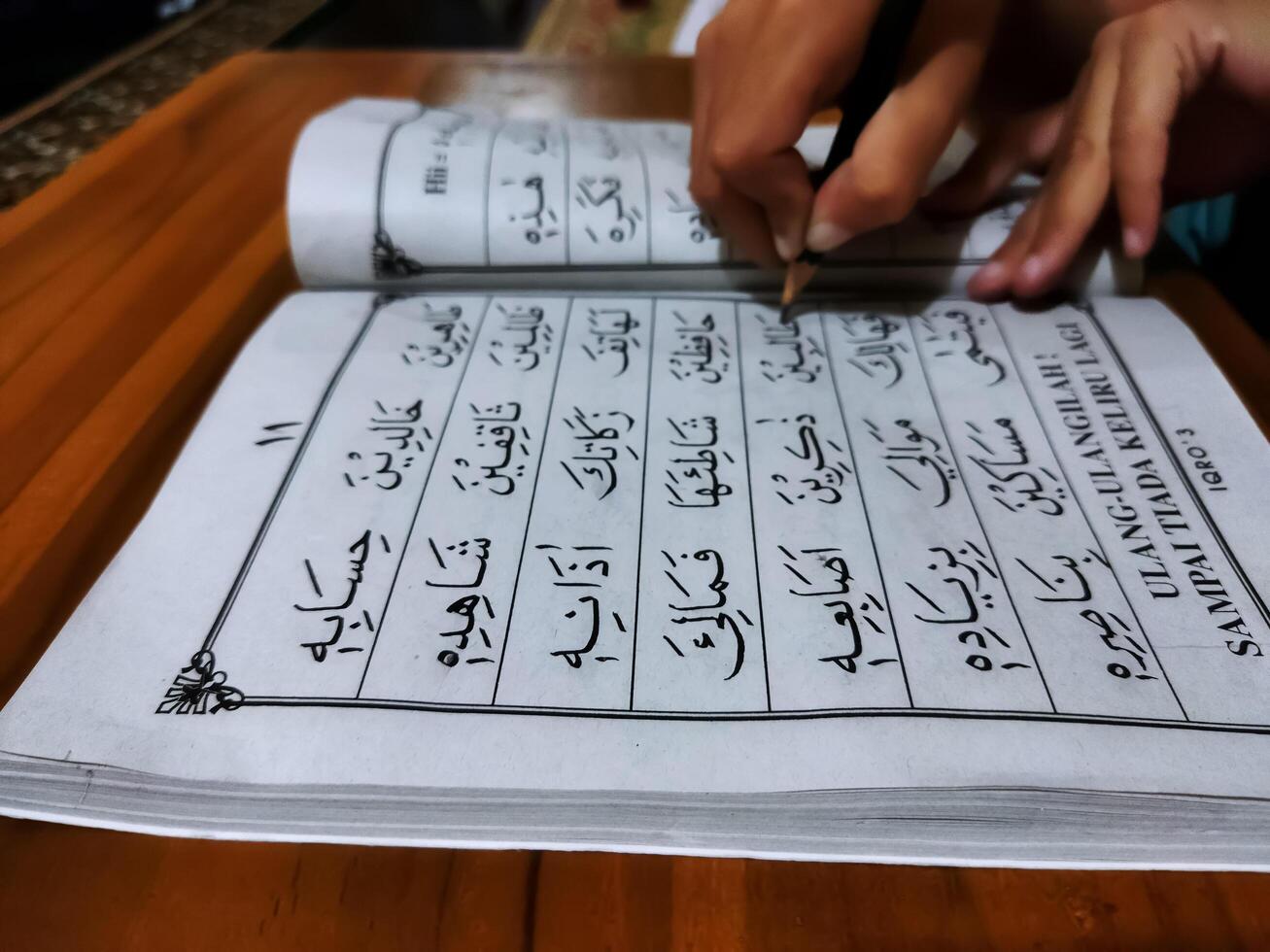 Bekonang, Sukoharjo, March 26, 2023. Islamic student is learning basic reading verses of the Quran by using the Iqra ', which is quick and clever methods at Islamic primary school. photo