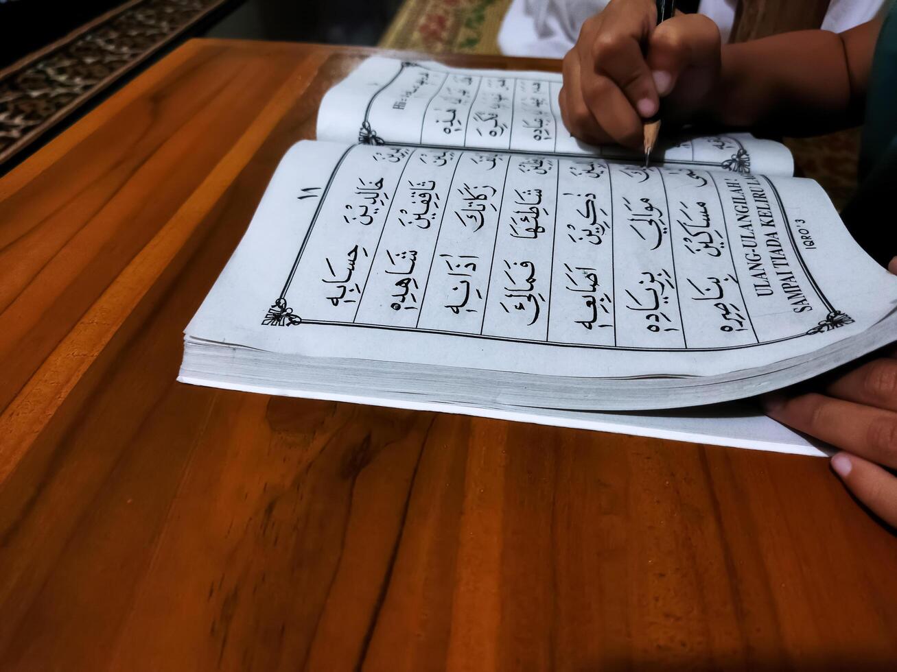 Bekonang, Sukoharjo, March 26, 2023. Islamic student is learning basic reading verses of the Quran by using the Iqra ', which is quick and clever methods at Islamic primary school. photo