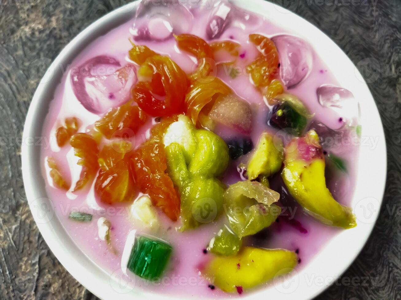 Es buah or sop buah-is an Indonesian iced fruit cocktail dessert. This cold and sweet beverage is made of diced fruits mixed with shaved ice or ice cubes, and sweetened with liquid sugar or syrup. photo