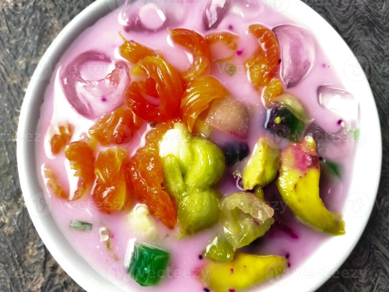 Es buah or sop buah-is an Indonesian iced fruit cocktail dessert. This cold and sweet beverage is made of diced fruits mixed with shaved ice or ice cubes, and sweetened with liquid sugar or syrup. photo