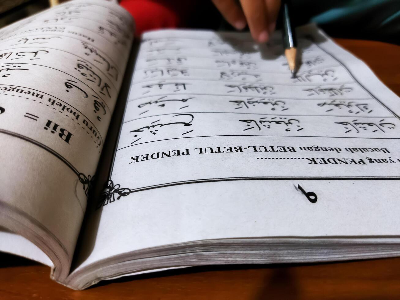 Bekonang, Sukoharjo, March 26, 2023. Islamic student is learning basic reading verses of the Quran by using the Iqra ', which is quick and clever methods at Islamic primary school. photo