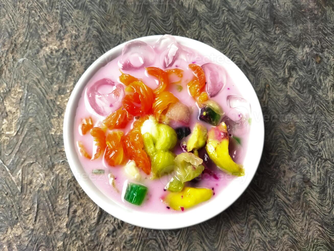Es buah or sop buah-is an Indonesian iced fruit cocktail dessert. This cold and sweet beverage is made of diced fruits mixed with shaved ice or ice cubes, and sweetened with liquid sugar or syrup. photo