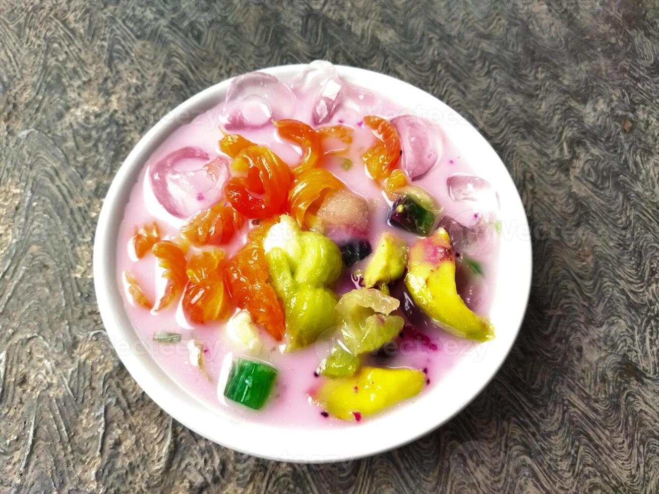 Es buah or sop buah-is an Indonesian iced fruit cocktail dessert. This cold and sweet beverage is made of diced fruits mixed with shaved ice or ice cubes, and sweetened with liquid sugar or syrup. photo