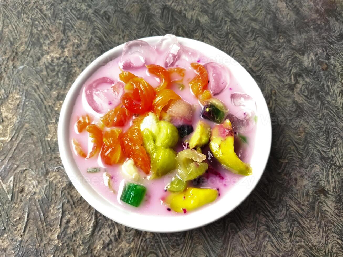 Es buah or sop buah-is an Indonesian iced fruit cocktail dessert. This cold and sweet beverage is made of diced fruits mixed with shaved ice or ice cubes, and sweetened with liquid sugar or syrup. photo