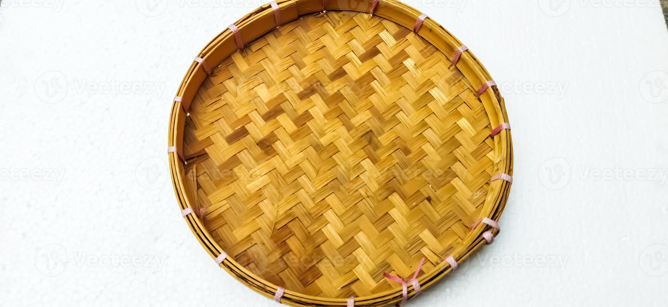 Indonesia's popular traditional handicraft, Tampah. In the form of a tray made of woven bamboo. Isolated on white background. photo