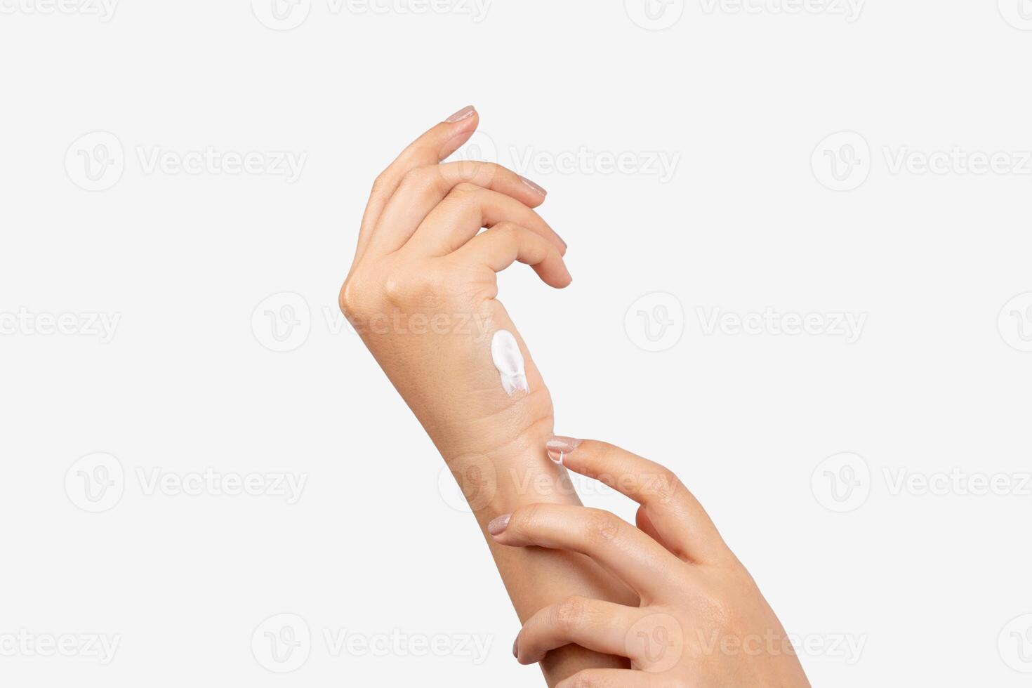 Female applying cream to her hands on a white background photo