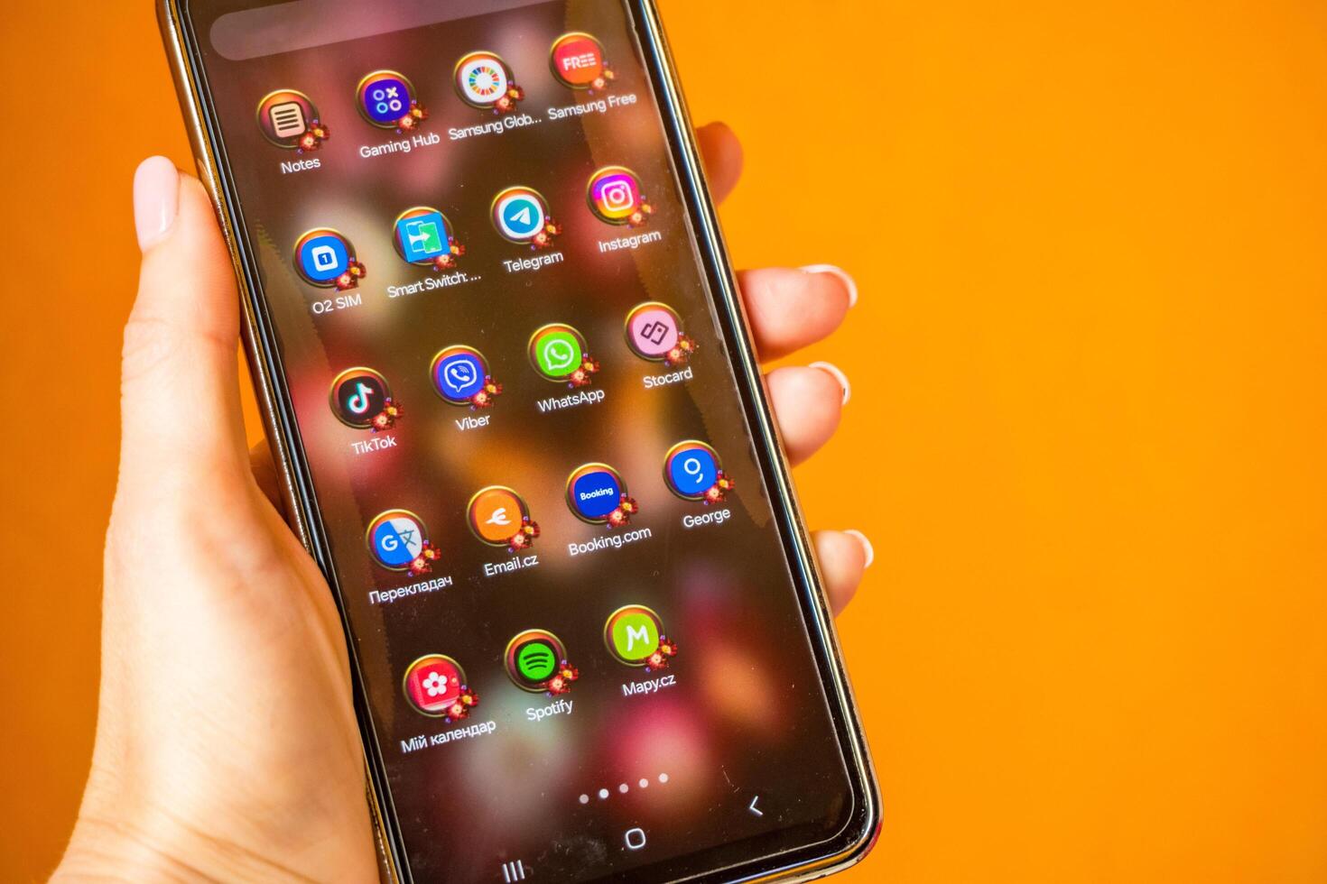 Prague- Czech- 22 July 2024. Woman using mobile phone with home screen opened showing everyday app icons photo