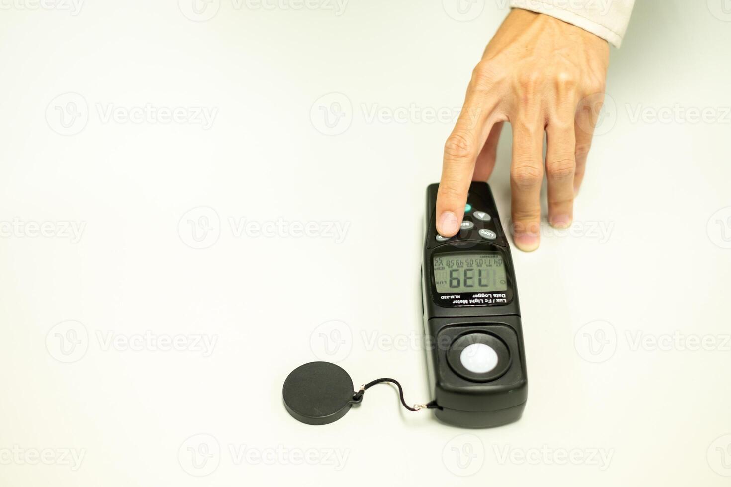 An electrical worker's hand is holding a light meter in the workplace isolated on white background, lighting, light meter, occupational safety, occupational health, office electric light photo