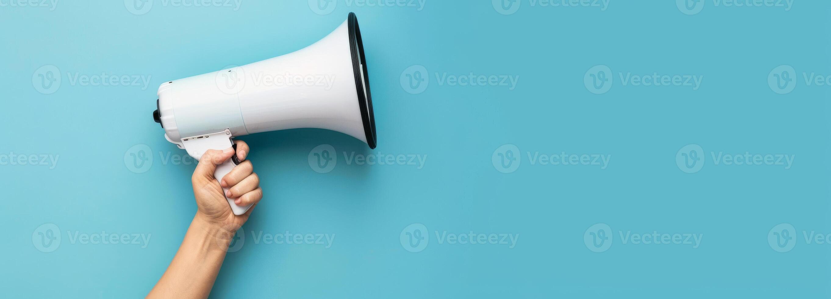 Megaphone in Hand on Blue Background with Copy Space photo