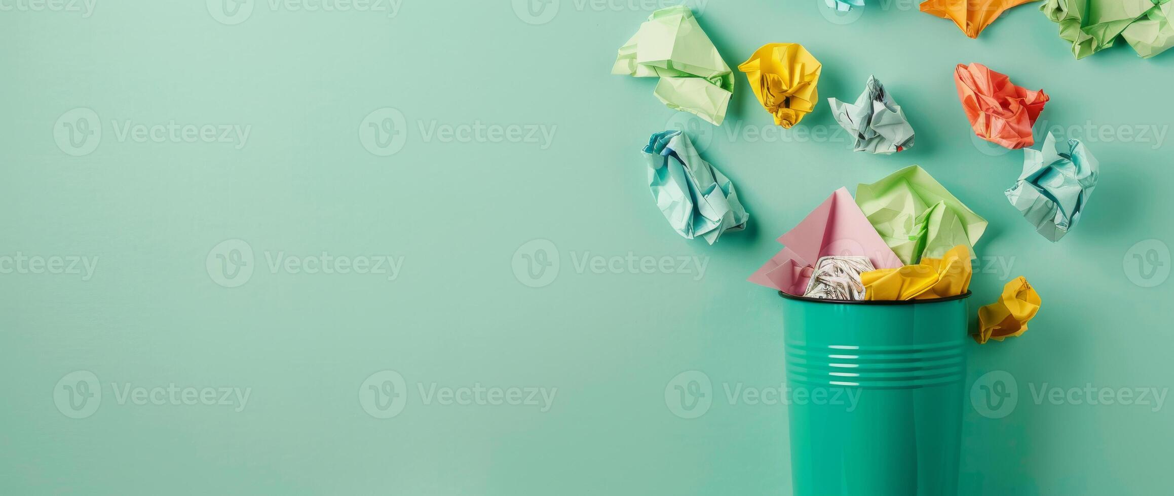 Colorful Crumpled Paper and Green Trash Bin on Green Background with Copy Space photo