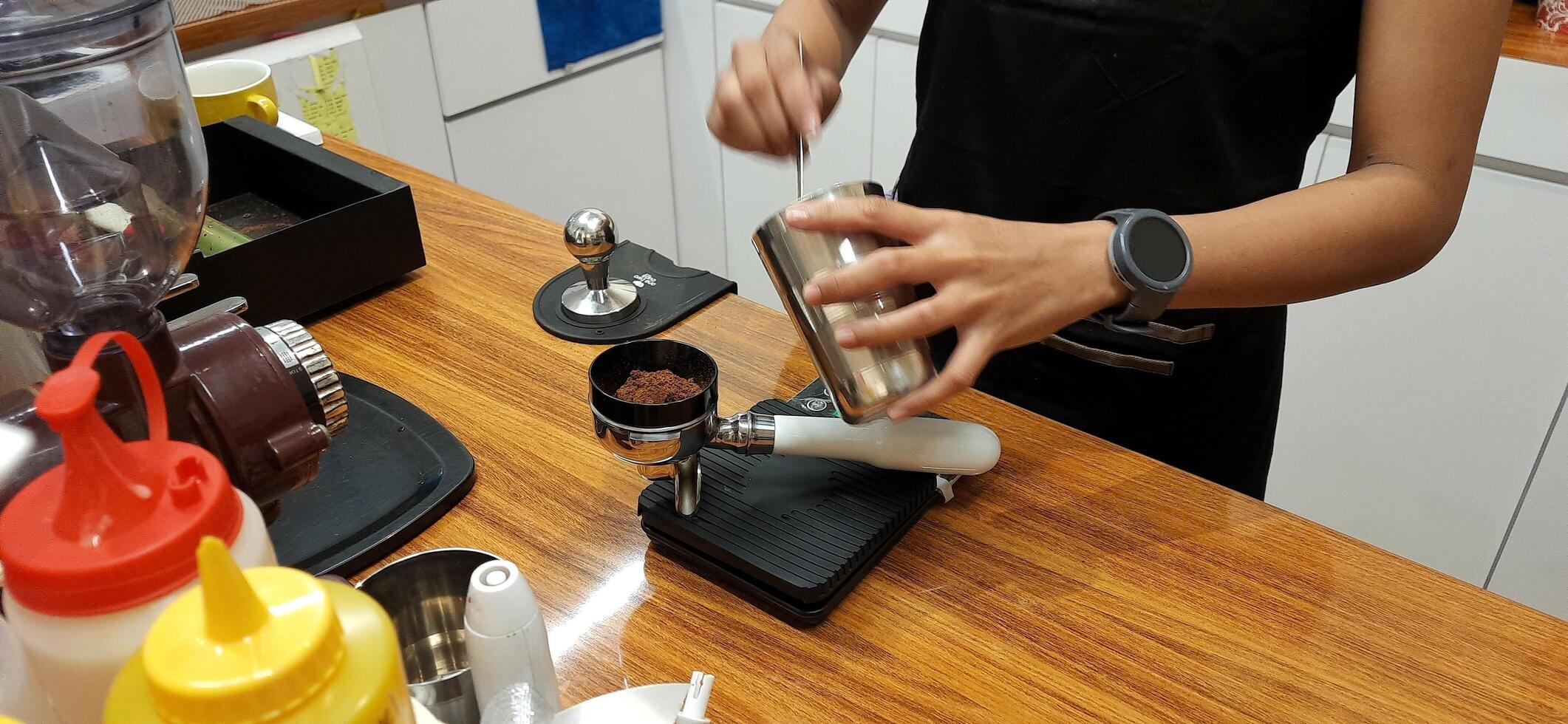 Close up Barista making coffee for customer in cafe. Woman working in coffee shop wearing an apron. Makassar, South Sulawesi, Indonesia - August 11 2024 photo