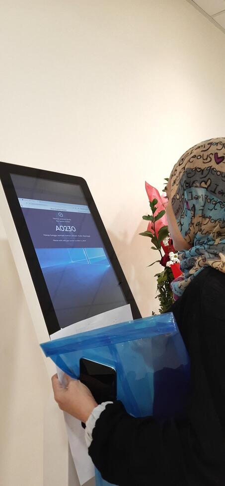 Modern self check in machine for patient registration in hospitals. Makassar, South Sulawesi, Indonesia - August 12 2024 photo