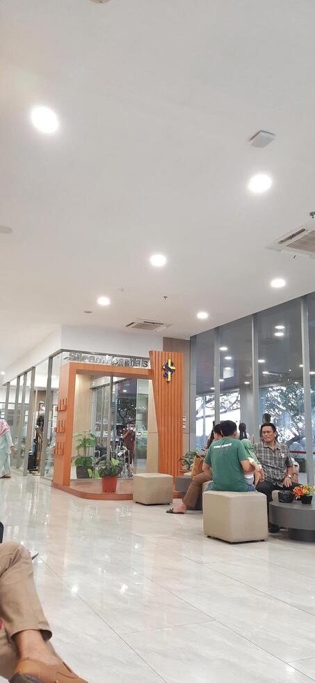 Atmosphere of patient queues to receive medical services at waiting area hospital. Makassar, South Sulawesi, Indonesia - August 12 2024 photo