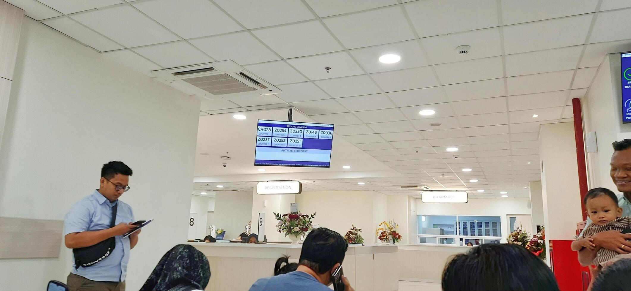 Atmosphere of patient queues to receive medical services at waiting area hospital. Makassar, South Sulawesi, Indonesia - August 12 2024 photo