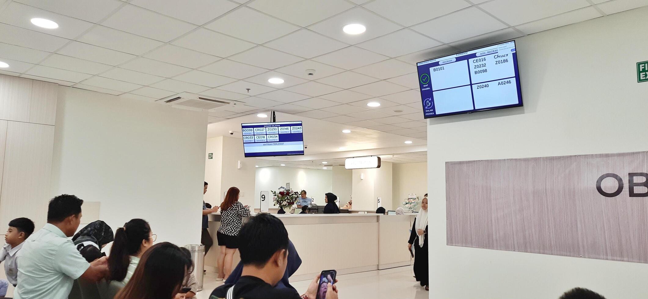 Atmosphere of patient queues to receive medical services at waiting area hospital. Makassar, South Sulawesi, Indonesia - August 12 2024 photo