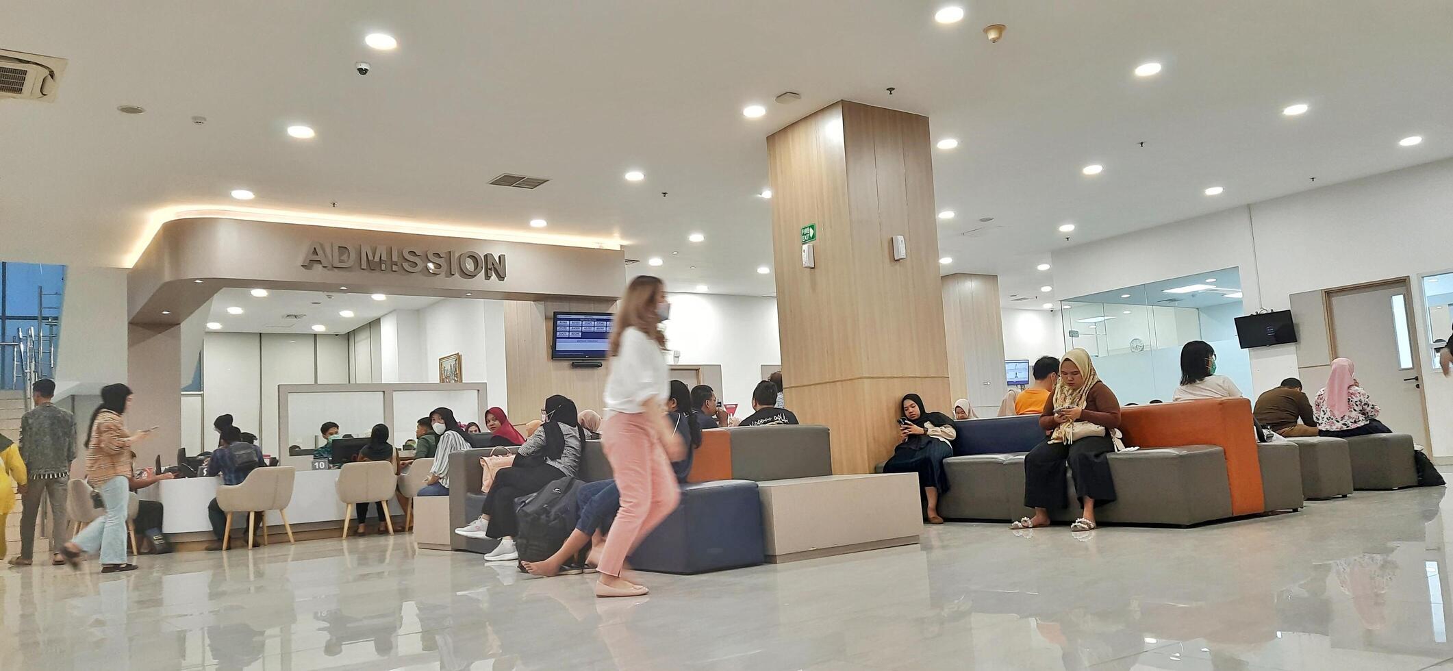 Atmosphere of patient queues to receive medical services at waiting area hospital. Makassar, South Sulawesi, Indonesia - August 12 2024 photo