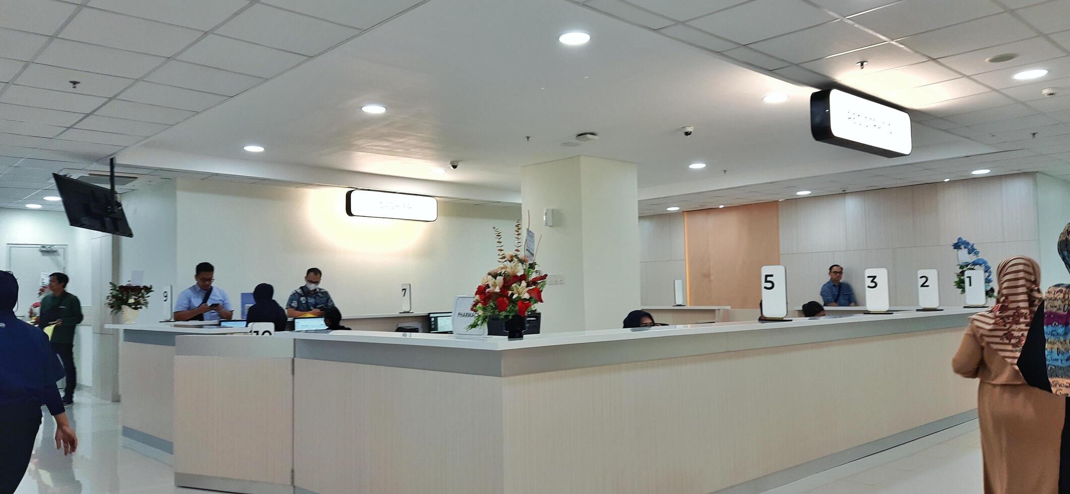 Atmosphere of patient queues to receive medical services at waiting area hospital. Makassar, South Sulawesi, Indonesia - August 12 2024 photo