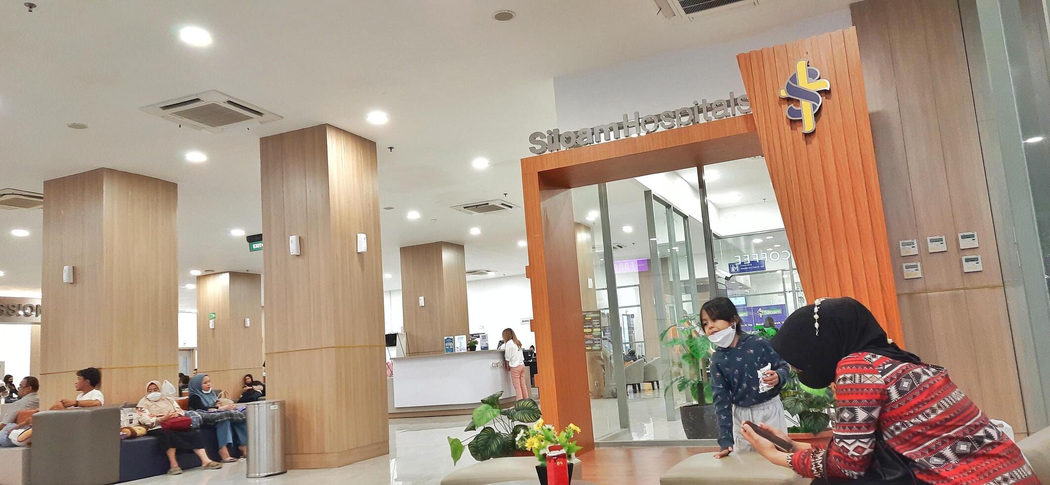Atmosphere of patient queues to receive medical services at waiting area hospital. Makassar, South Sulawesi, Indonesia - August 12 2024 photo
