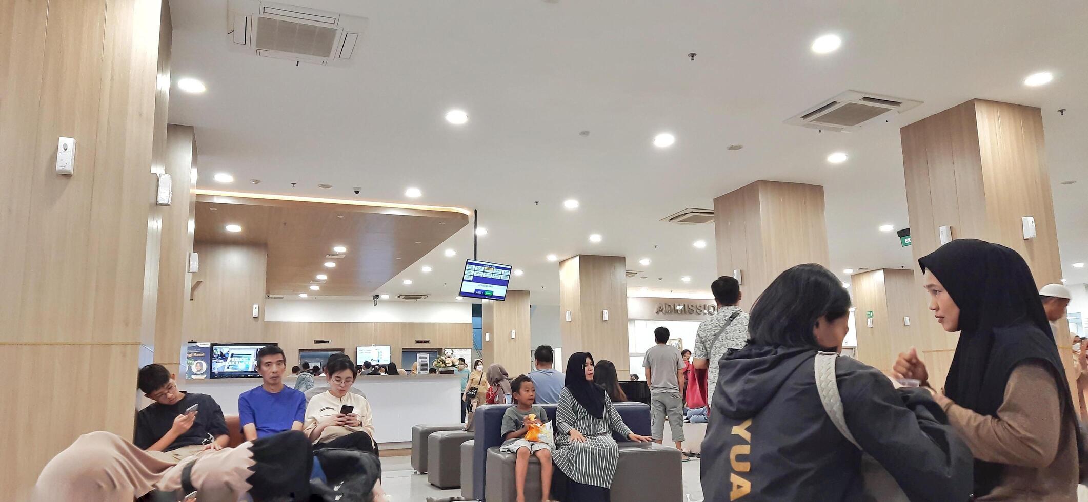Atmosphere of patient queues to receive medical services at waiting area hospital. Makassar, South Sulawesi, Indonesia - August 12 2024 photo