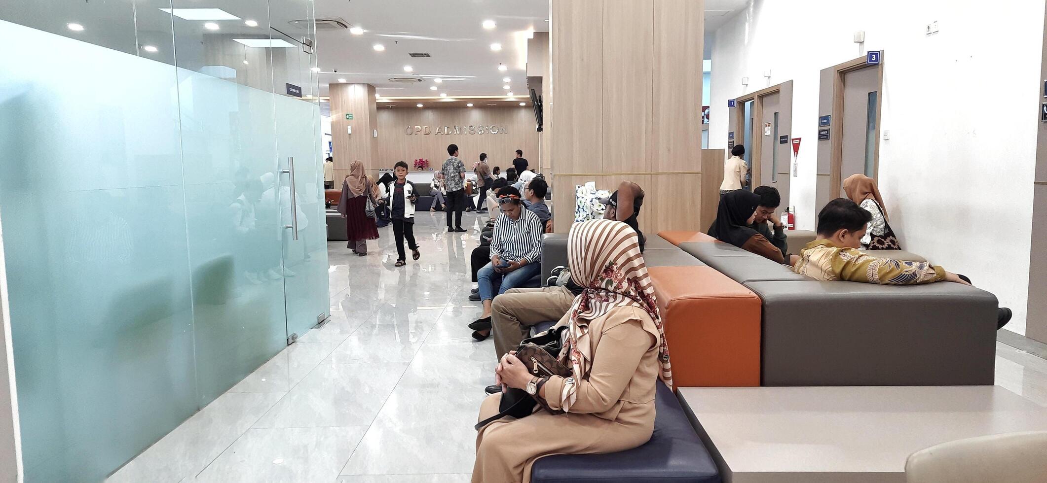 Atmosphere of patient queues to receive medical services at waiting area hospital. Makassar, South Sulawesi, Indonesia - August 12 2024 photo