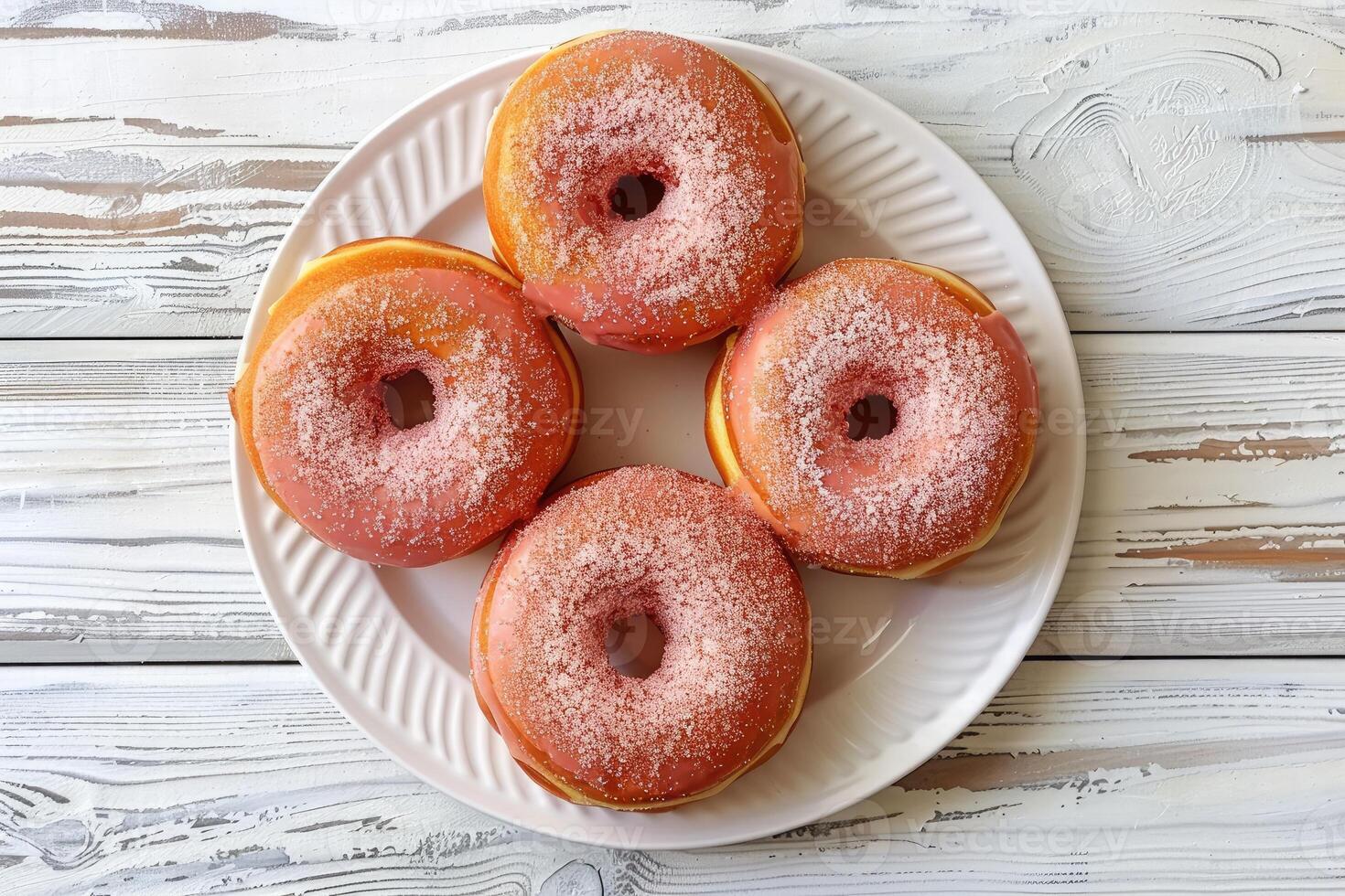 Top view of glazed donuts on white plate and wooden table. Sweets and pastries for backgrounds for confectioneries and cafes photo
