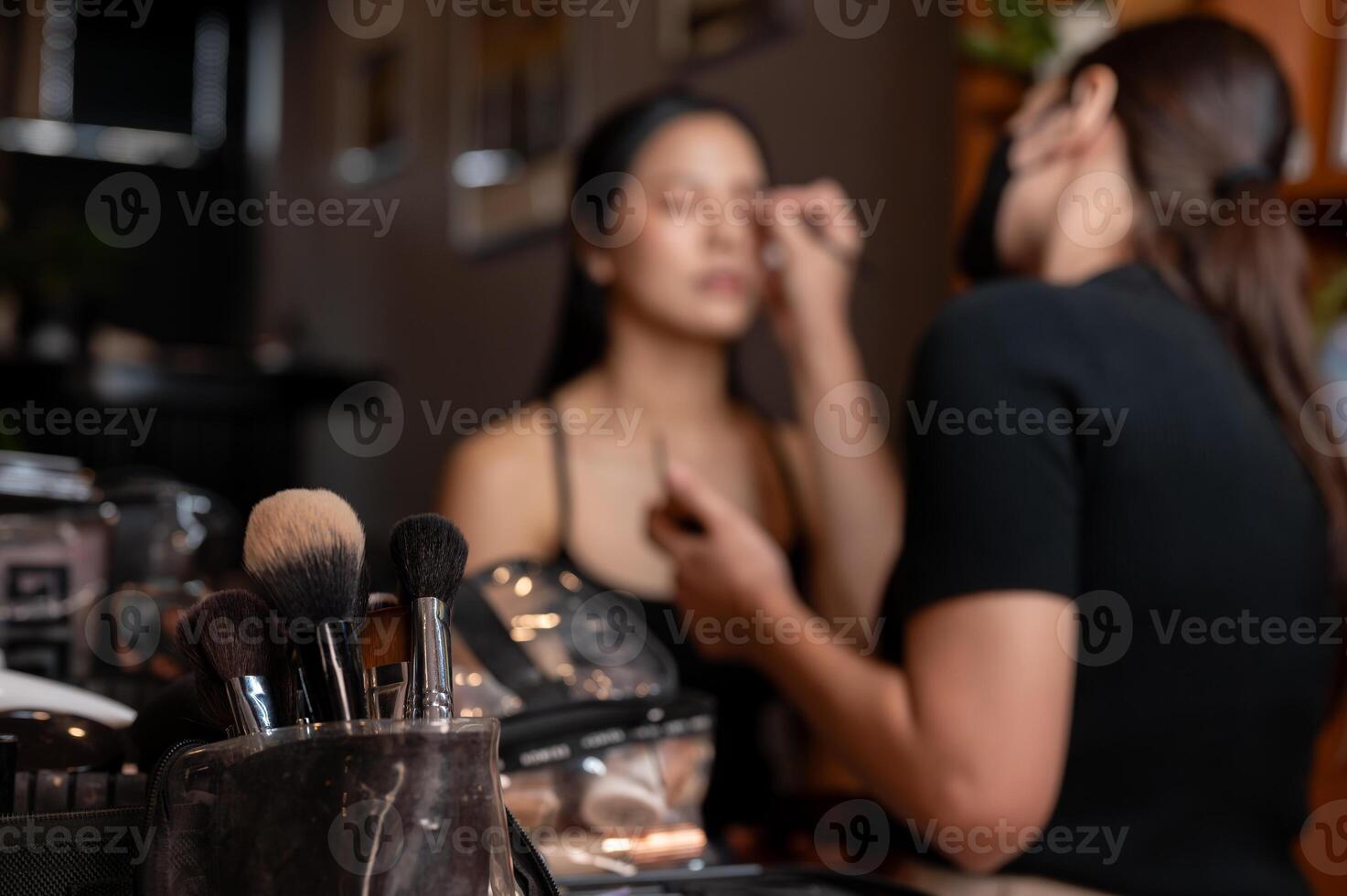 In a makeup studio, a set of makeup brushes in a bag on the table is in selective focus. photo