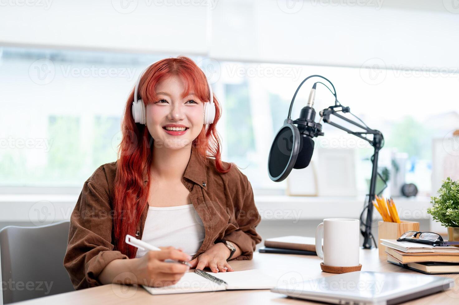 A charming Asian female podcaster is listening to her guest's answers during a remote interview. photo