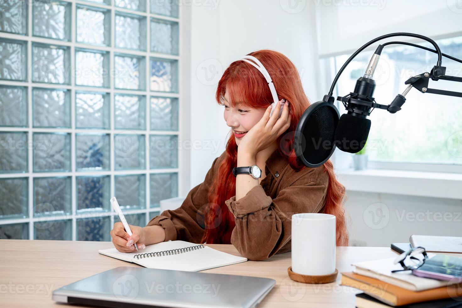 A charming Asian female radio host is conducting a remote interview from her studio. photo