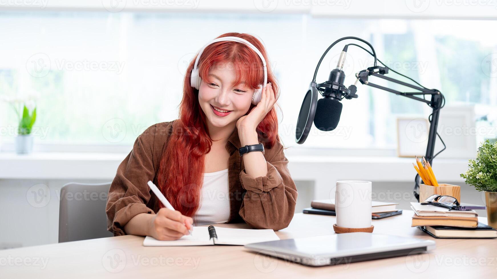 A charming Asian female podcaster is listening to her guest's answers during a remote interview. photo