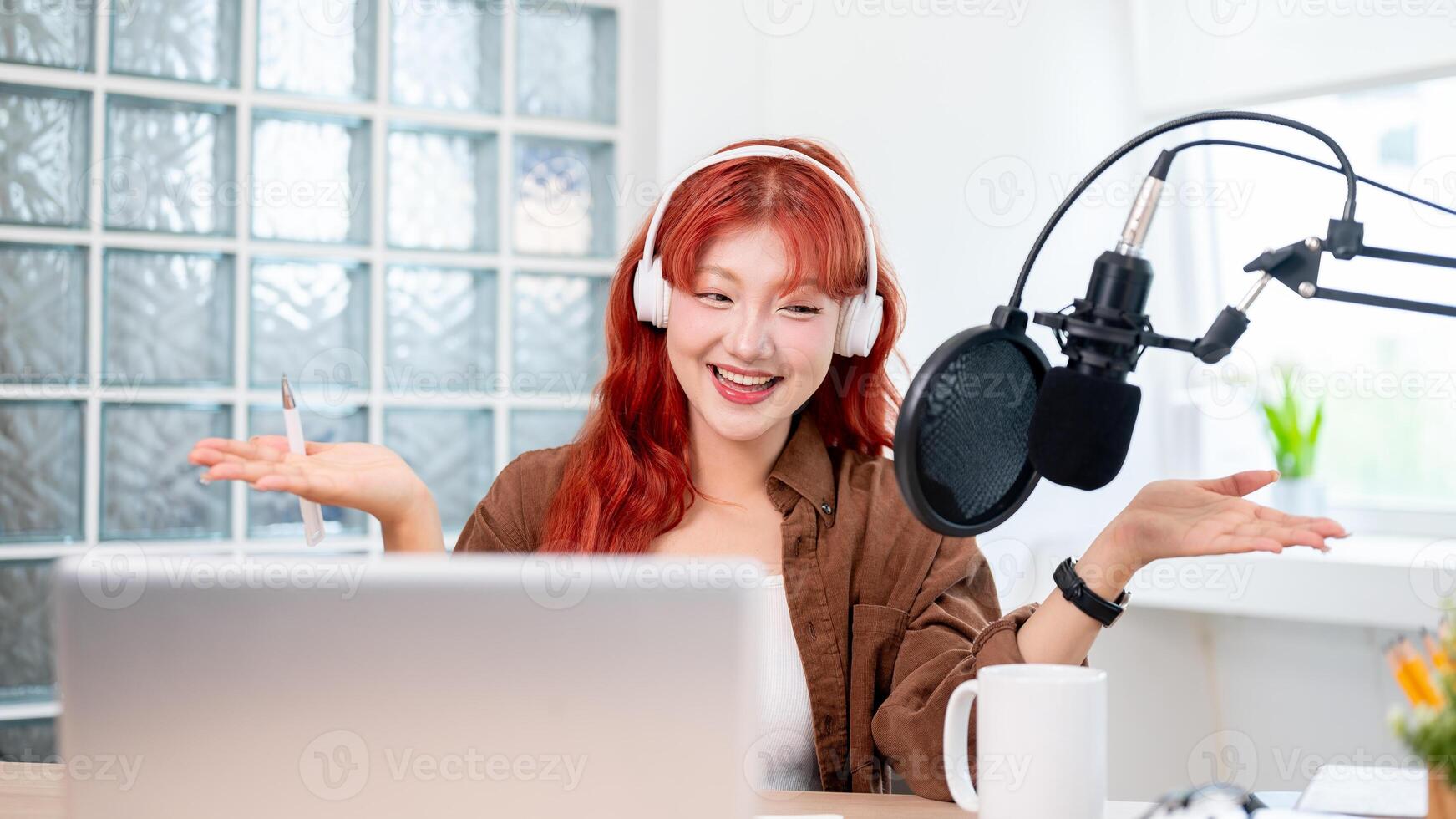 A cheerful Asian female podcaster is enjoying conducting her podcast in the studio. photo