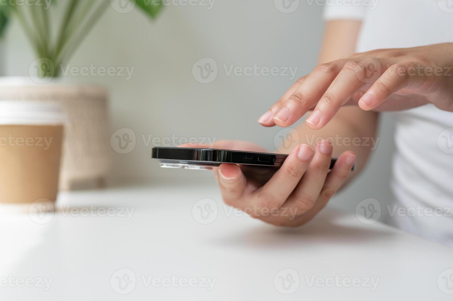 A cropped image of a woman using her smartphone while relaxing in a coffee shop. photo