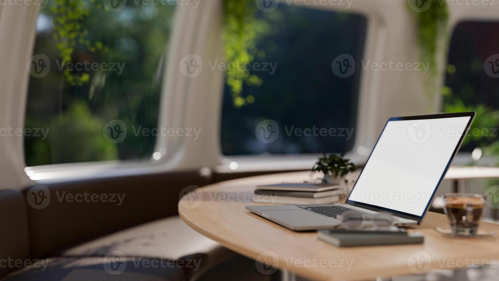 A side view image of a laptop on a wooden table in a contemporary coffee shop or office lounge. photo