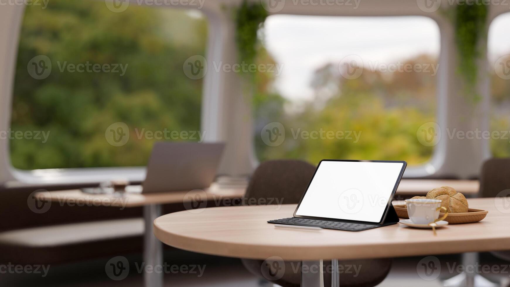 A digital tablet mockup on a wooden table in a contemporary cafe co-working space. photo