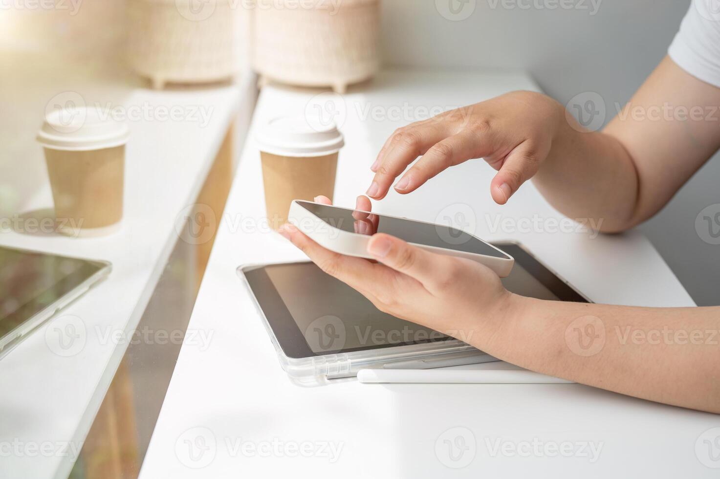 A close-up side view image of a woman using her smartphone while sitting in a coffee shop. photo