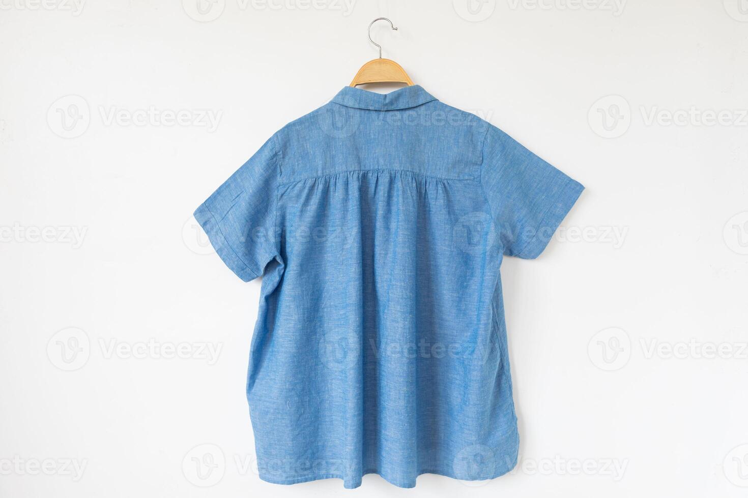 blue blouse is clothes hanger on white background. photo