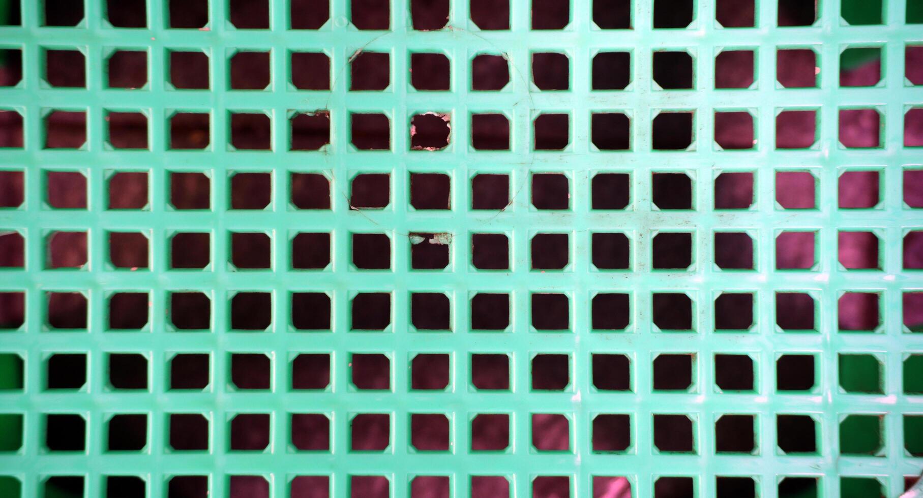 Abstract background of green plastic lattice with square holes. photo