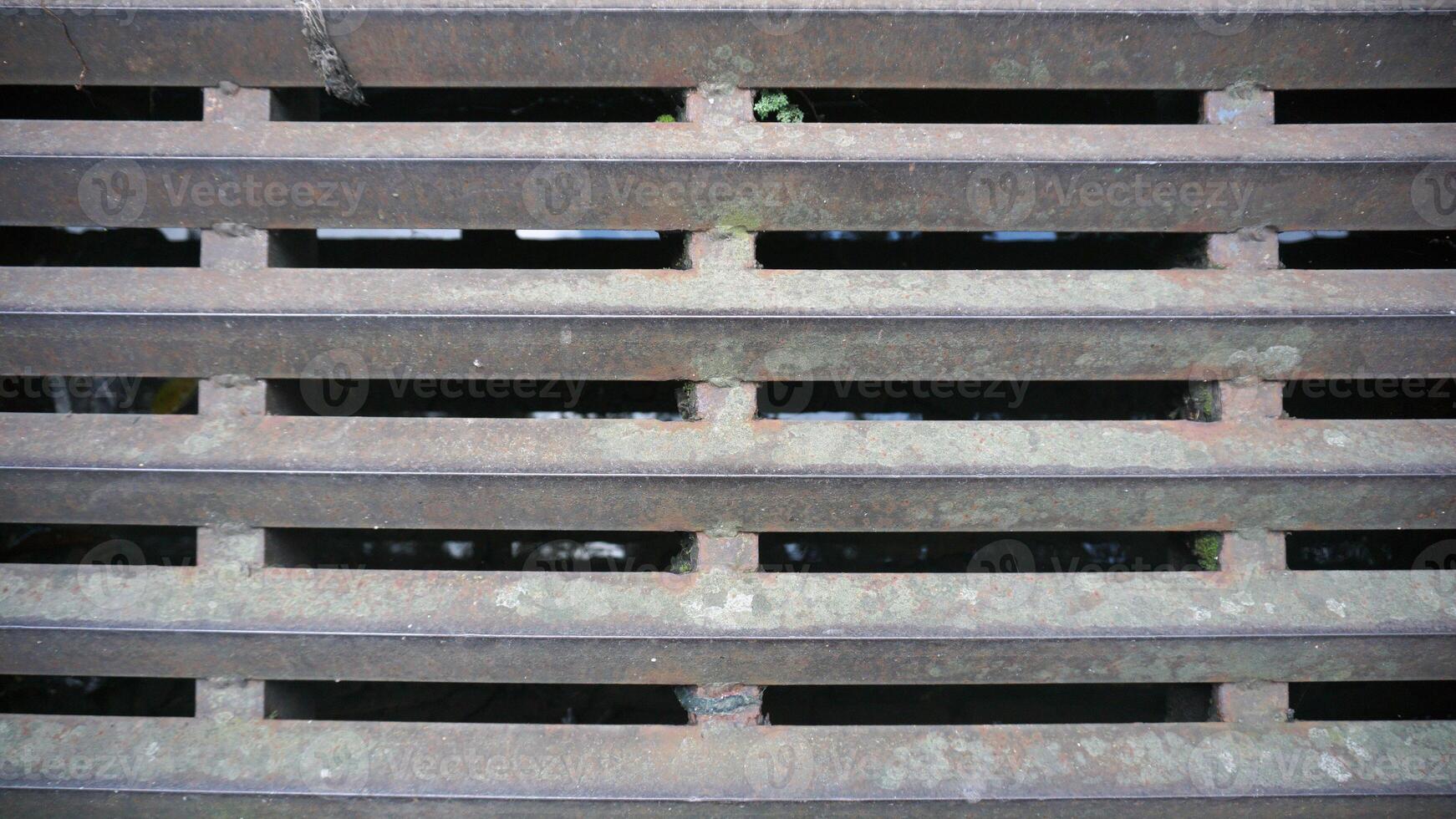 rusty iron grating water in the garden, old vintage metal texture background. photo