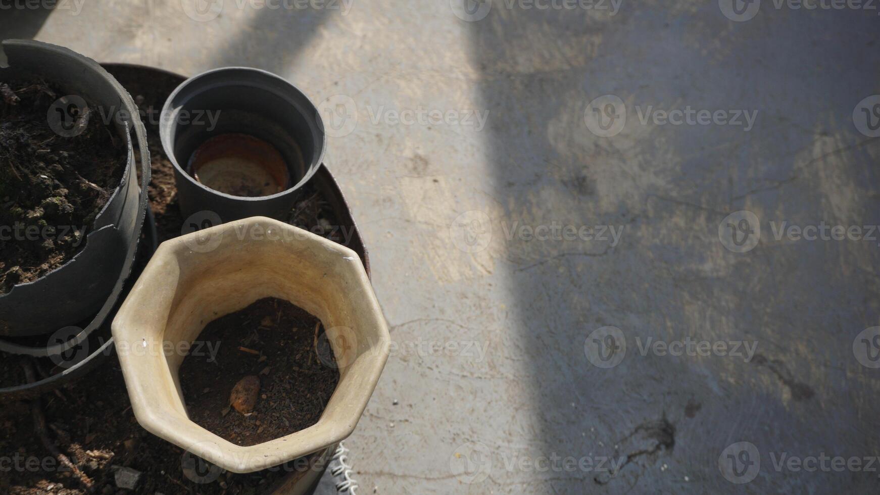 Flower pots and clay pots on the cement floor in the backyard with space for text. photo