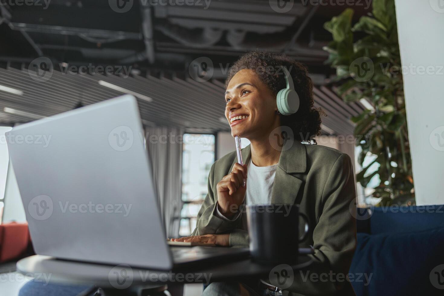 A whitecollar worker wearing headphones is using a laptop computer at a table photo