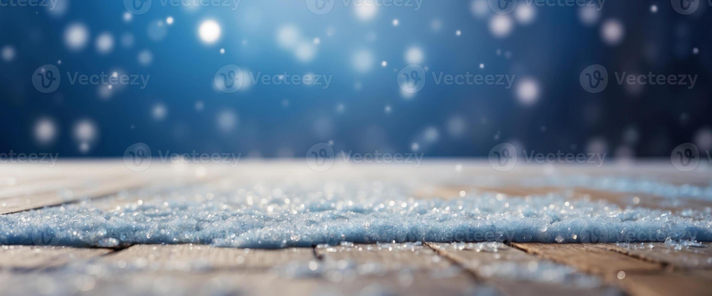 Beautiful winter snowy blurred defocused blue background and empty wooden flooring Flakes of snow fall and sparkle on light, copy space. photo