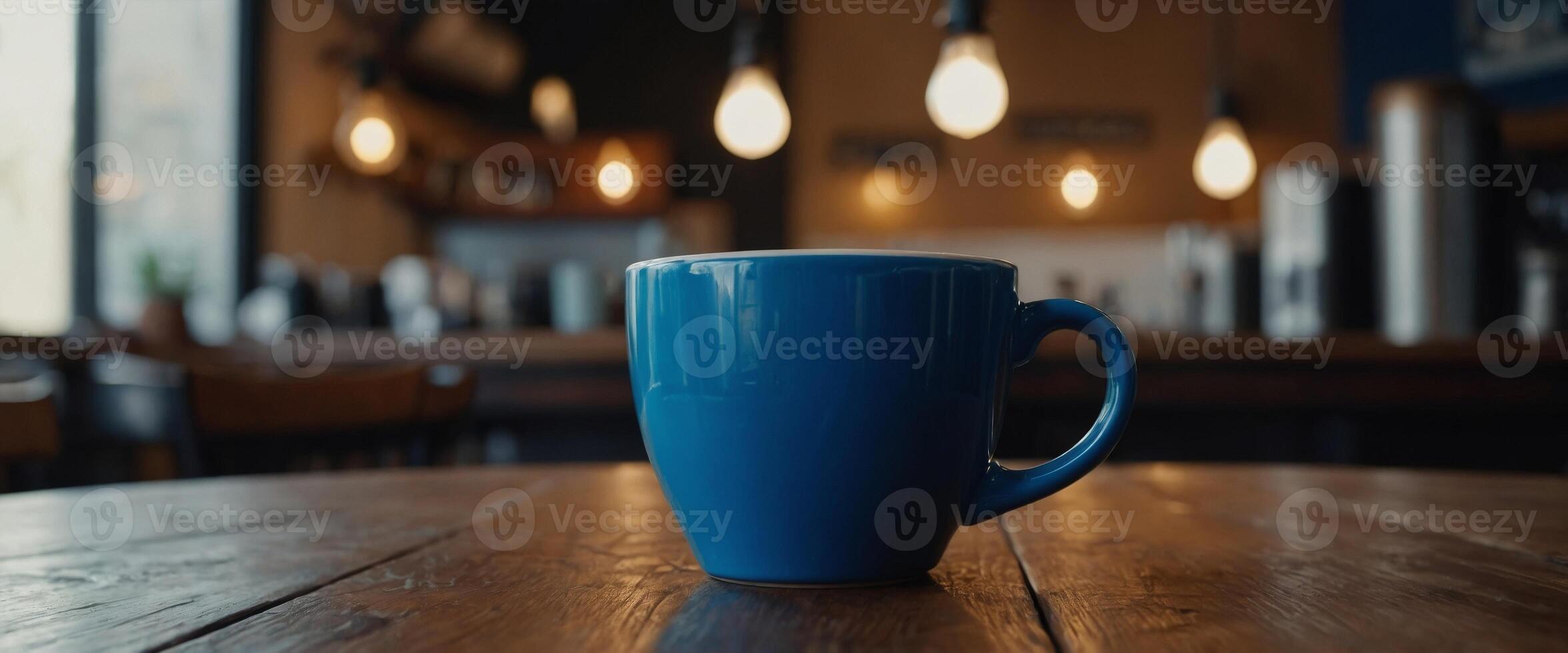 Coffee in blue cup on wooden table in cafe with lighting background. photo