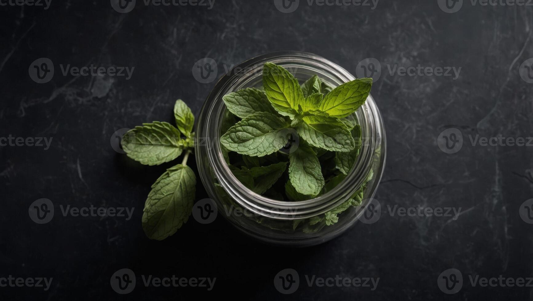 Dried peppermint in a glass jar and a bunch of fresh mint, medicine herb on black background, top view. photo