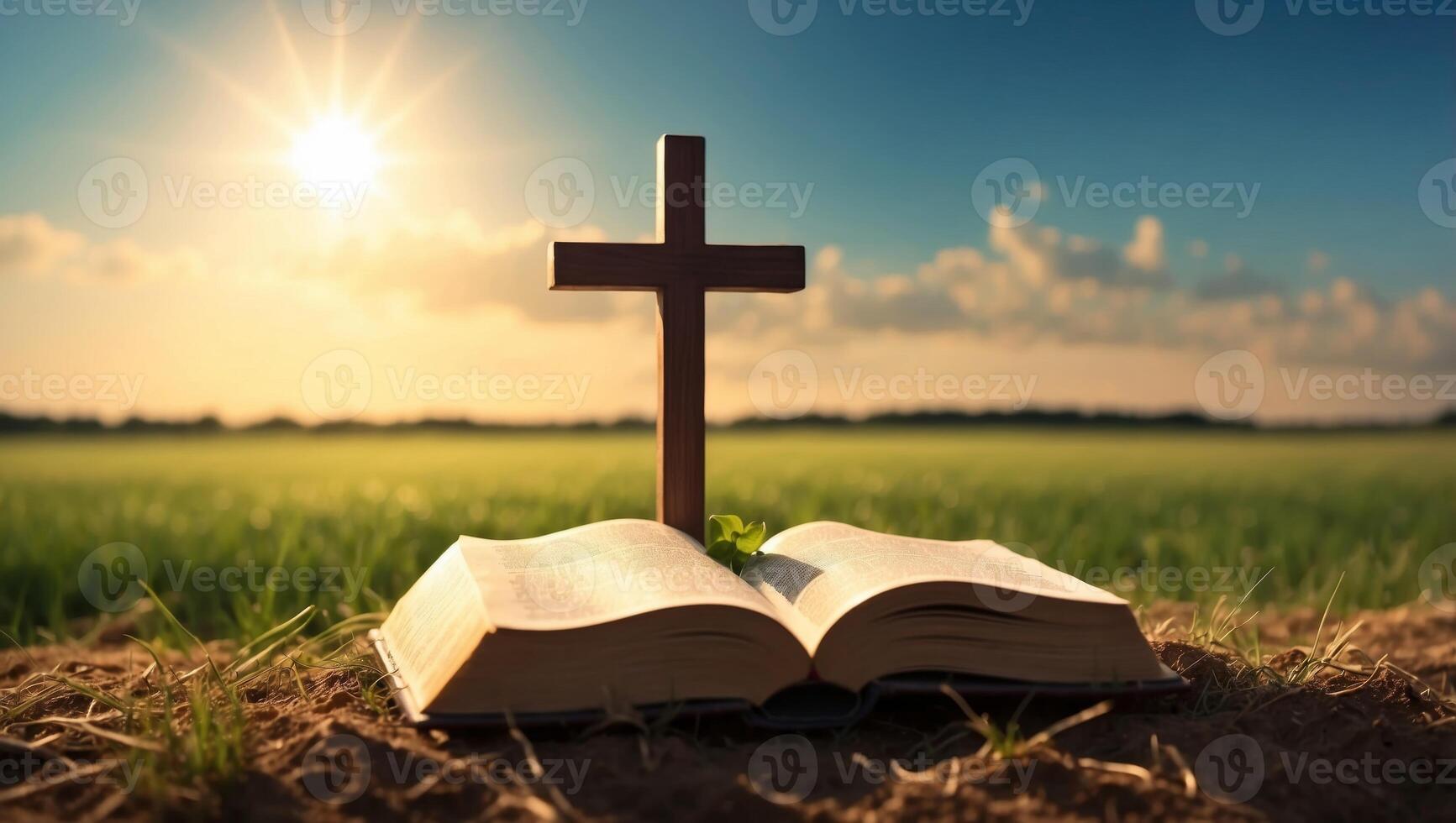 Cross on the Holy Bible in the field with the sun in the background. photo