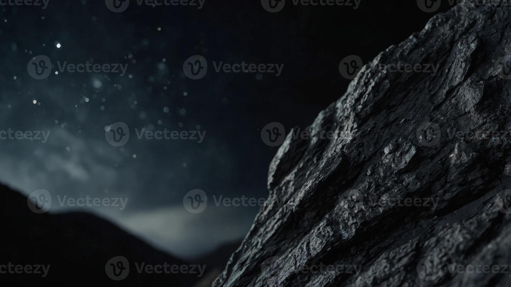 Vertical image of a black rock on a black background. photo