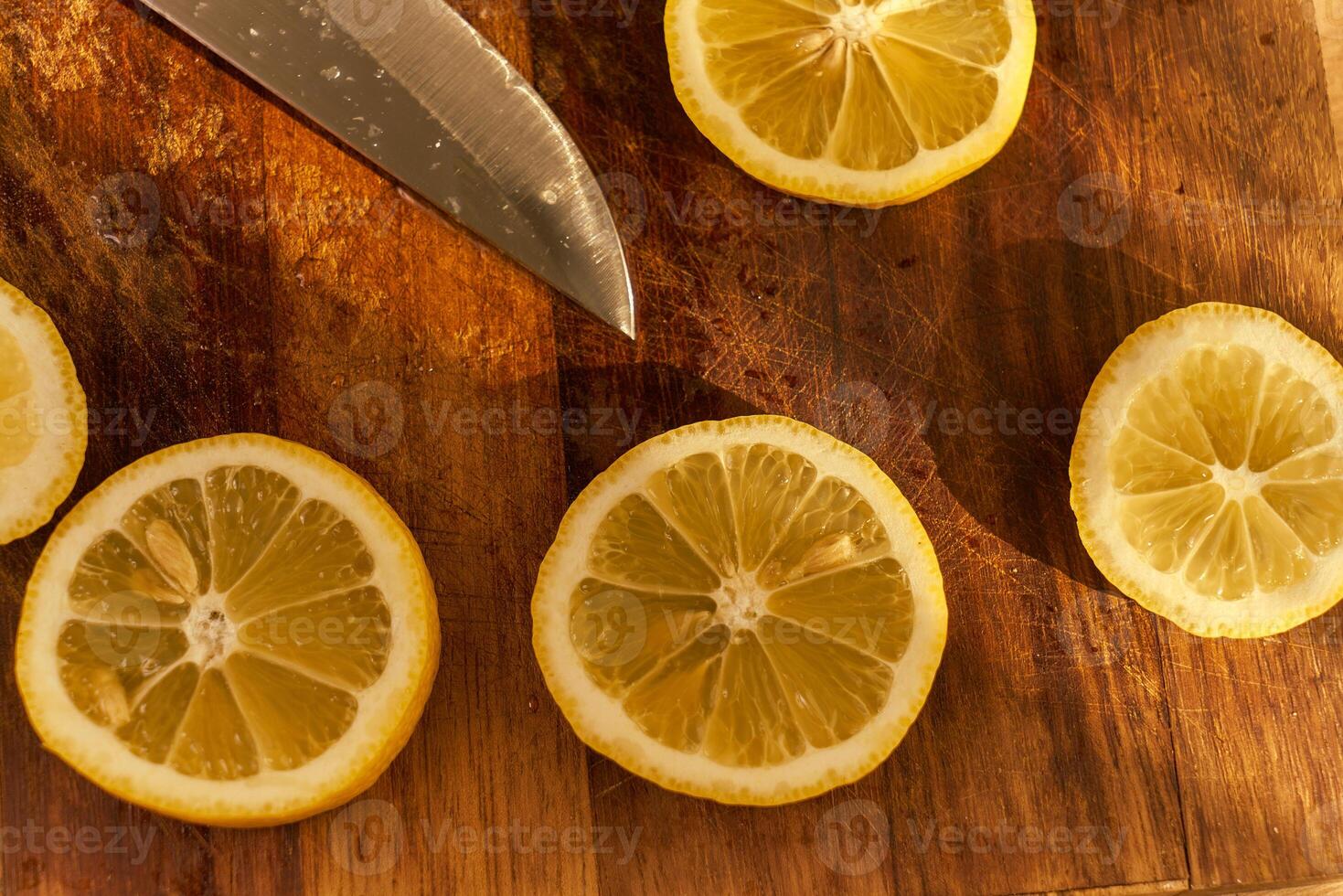 Slices of organic lemon on a wooden cutting board photo