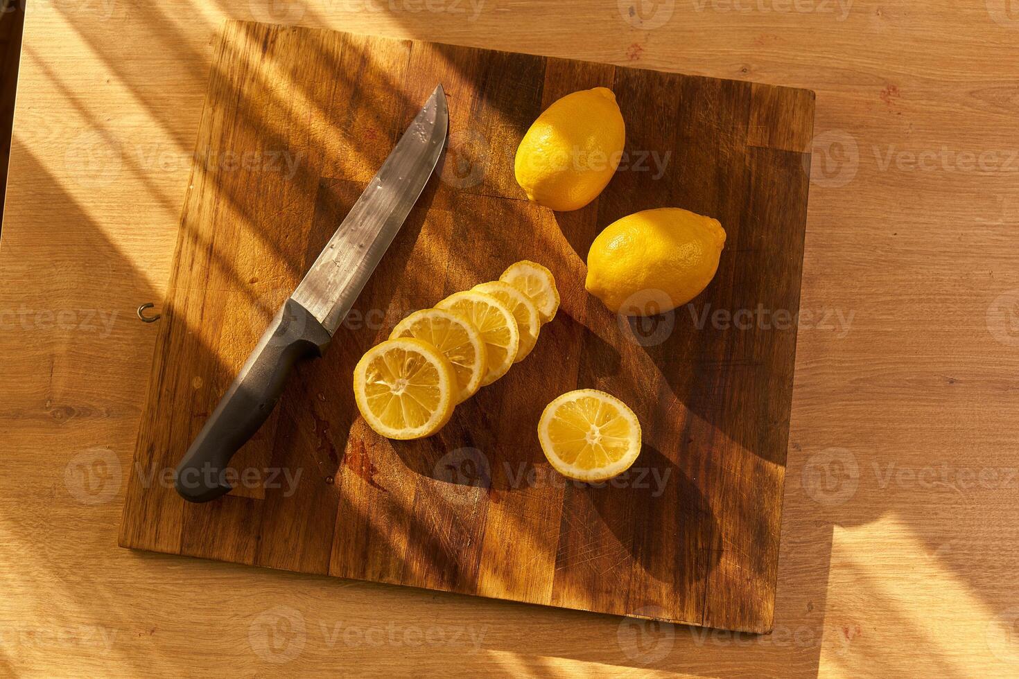 Slices of organic lemon on a wooden cutting board photo