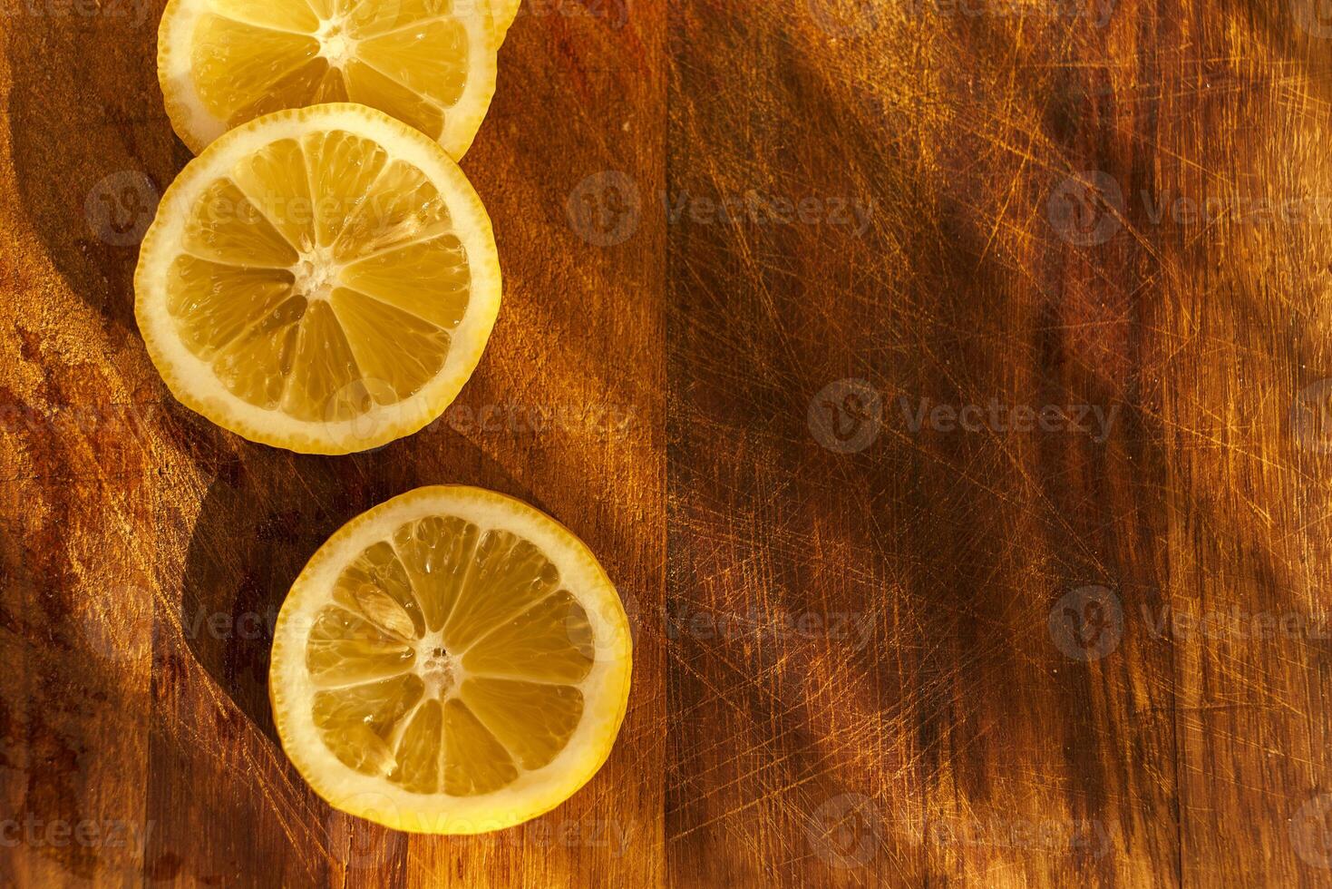 Slices of organic lemon on a wooden cutting board photo