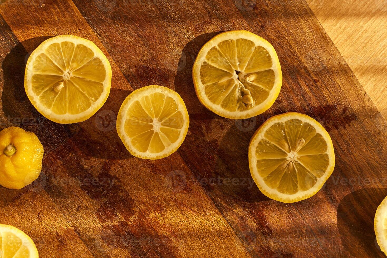 Slices of organic lemon on a wooden cutting board photo